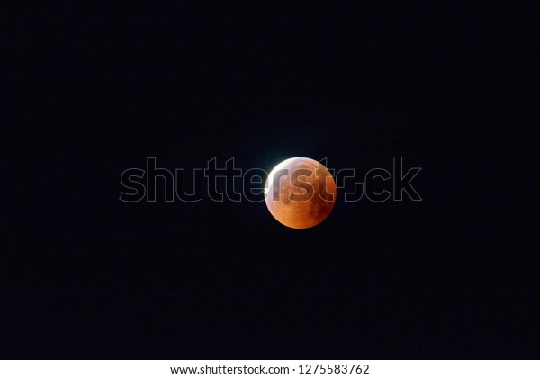 Red moon, total lunar eclipse.\
A total moon\
eclipse in the dark night\
sky.\
