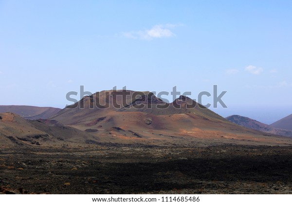 Red mountains\
and volcanic black land in Lanzarote Island looking like martian\
landscape, Canary Islands,\
Spain