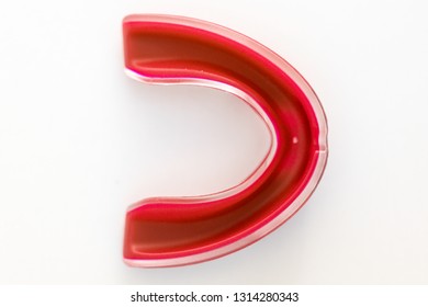 Red Mouth Guard Used To Protect Teeth On A White Background