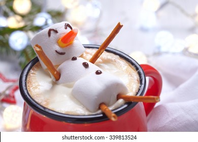 Red mug with hot chocolate with melted marshmallow snowman - Shutterstock ID 339813524