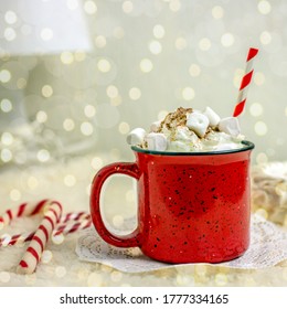 Red mug with hot cocoa and marshmallows. Concept for New Year's drink on a festive table, square size, bokeh effect. Nearby are sweet canes and snowflakes. - Powered by Shutterstock