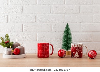 Red mugs with Christmas pattern, candle set, red ball and decorative Christmas tree on kitchen countertop. Festive kitchen background. minimalism - Powered by Shutterstock