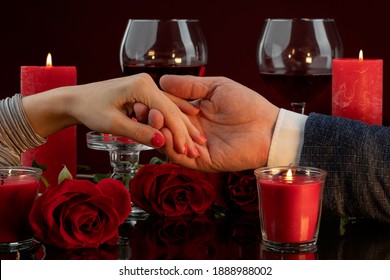 Red Nail Polish On A Woman's Hand, Manicure For A Gala Evening. The Male Hand Gently Holds Female Fingers.