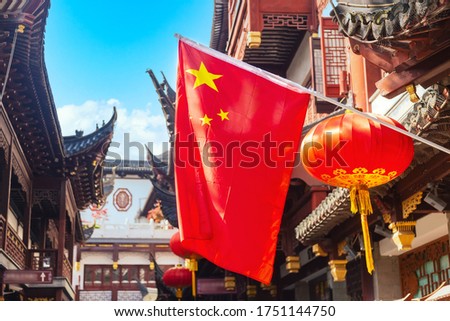 Red national flag of China against old chinese buildings at Yuyuan Garden in Shanghai, China