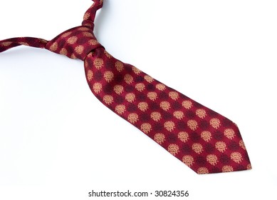 Red necktie with a strange pattern without a loop. Isolated on white background.