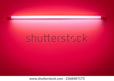 Red neon lamp on a white wall