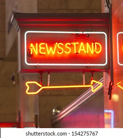 A Red Neon Sign Points The Way To The News Stand