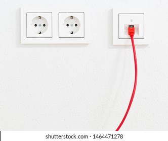 Red Network Cable In Wall Outlet For Office Or Private Home Lan Ethernet Connection With Power Outlets Flat View On White Plaster Wall Background