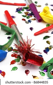 A Red Noise Maker With Confetti On A White Background.