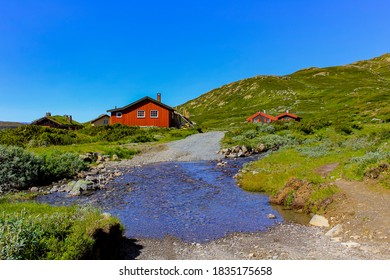 Red Norwegian huts on Vavatn lake and river in Hemsedal, Norway.