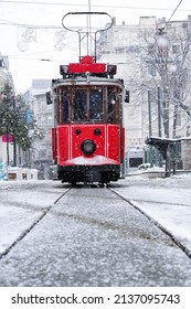 Red Nostalgic Tram Is Moving On The Istiklal Street In Beyoglu, Taksim. Winter Day With Snow. Cold Snowy Weather In Turkey. Flu Season.                                  