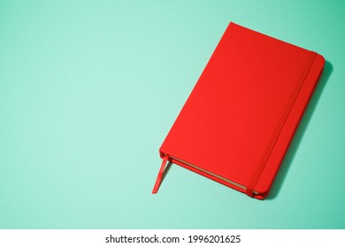 Red notebook on a green table.