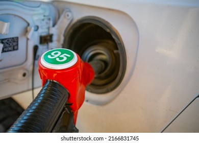 Red Nozzle Pump Gun Petrol From Oil Pump In The Car Tank To Refueling. High Quality Photo