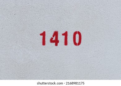 Red Number 1410 on the white wall. Spray paint.