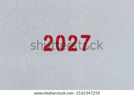 Red Number 2027 on the white wall. Spray paint.
