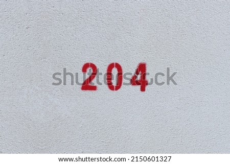 RED Number 204 on the white wall. Spray paint. 
