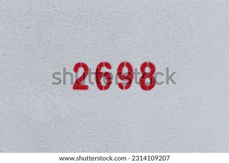 Red Number 2698 on the white wall. Spray paint.
