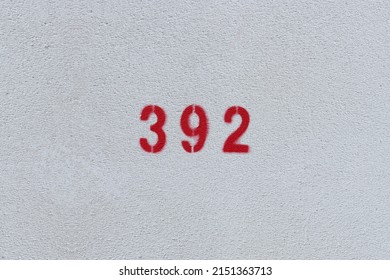 RED Number 392 on the white wall. Spray paint.three hundred ninety twothree hundred ninety two