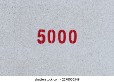 Red Number 5000 On The White Wall. Spray Paint.
