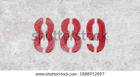 Red Number 889 on the white wall. Spray paint.