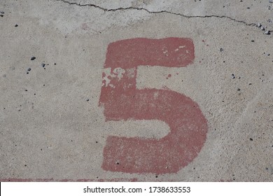 Red Number Five Paint On Old And Dirty Cement Ground. No. 5