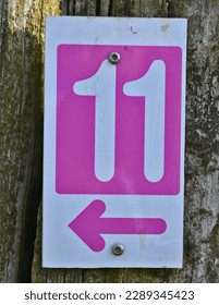 A red number plaque, showing the number eleven (number 11)  