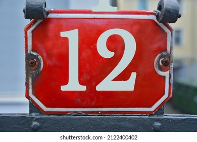 A red number plaque, showing the number   twelve (number 12)