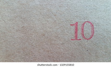 Red number ten on brown paper background  on  right side,
Kraft paper texture