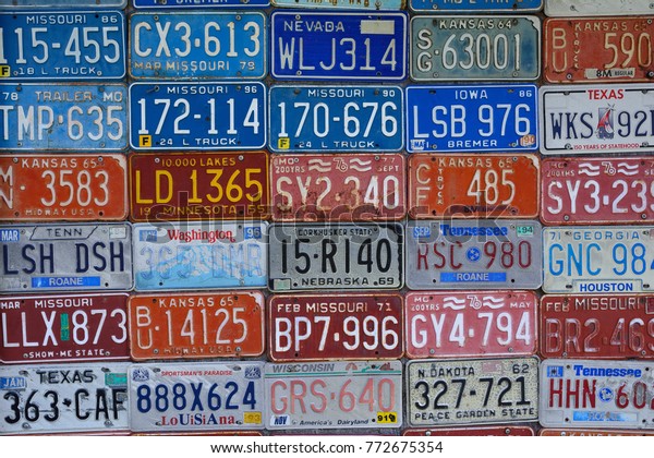 Red Oak, Missouri - July 19, 2017: Various old\
American license plates on wall. License plates are from various\
American states.