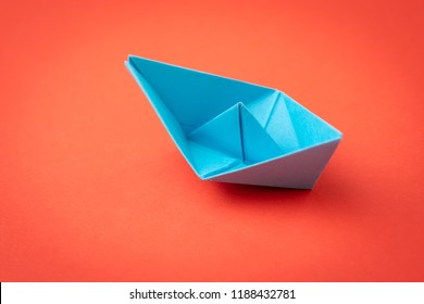 Red ocean business competition, survive success or winner company metaphor concept, blue origami paper ship on red background as ocean in minimal style.