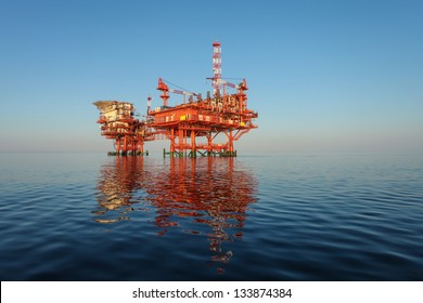 Red Oil Rig Platform On Calm Blue Sea