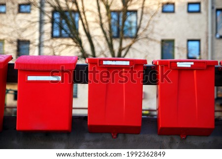 Red old post boxes with a house in a background