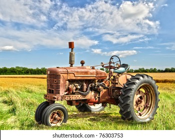 Red Old Rusty Tractor In A Field