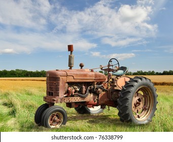 Red Old Rusty Tractor In A Field