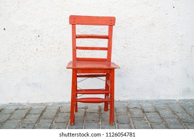 Red Old Vintage Wooden Chair On The White Wall. 