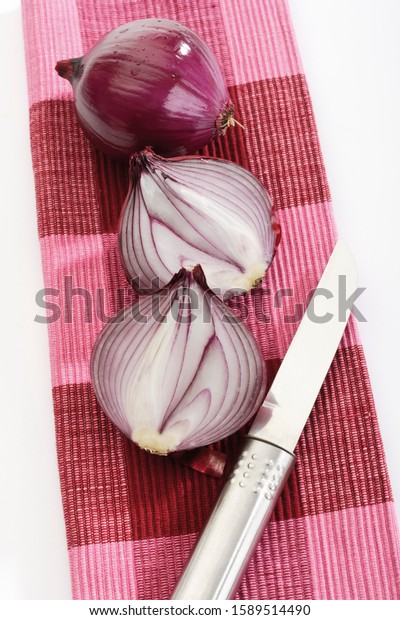 Red onion cut in half with\
knife