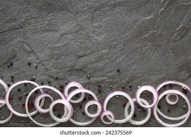 Red Onion Rings And Black Peppercorns On Dark Slate.  Food Background.