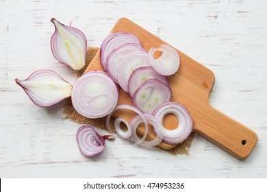 Red onion slices on rustic wooden table background