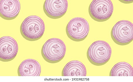 red onion slices on yellow background, top view flat lay composition