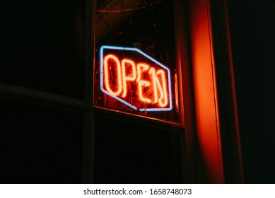 Red open neon sign glowing in the night. - Powered by Shutterstock