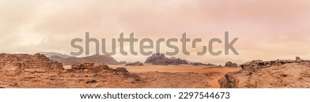 Red orange Mars like landscape in Jordan Wadi Rum desert, mountains background overcast morning, wide panorama. This location was used as set for many science fiction movies