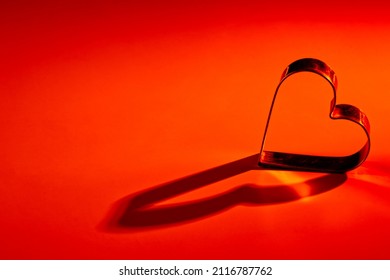 Red, orange yellow, gradient background. Metal heart. Lights and shadows. Love, wedding, Valentine 's day, engagement, romance, infatuation, marriage, fidelity, devotion, happiness, hot love, warmth. - Shutterstock ID 2116787762