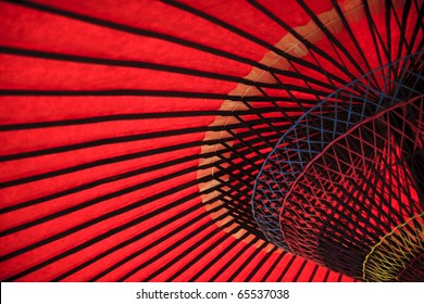 Red oriental paper umbrella open in bright sunlight