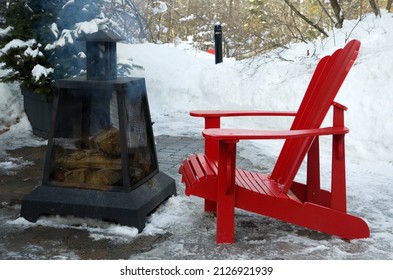 Red Outdoor Chairs With Smoking Fire Pit During Winter Horizontal