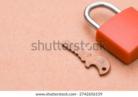 Red Padlock and Brass Key Representing Security and Access