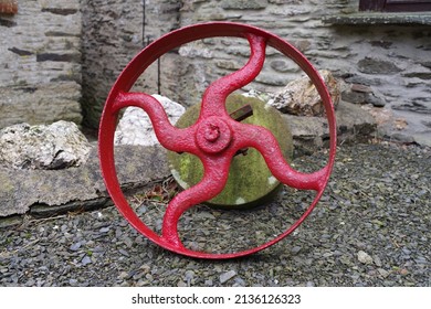 Red Painted Fly Wheel, Farm Machinery On Gravel