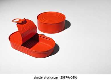 Red painted open tin can on gray background