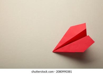 Red Paper Airplane On A Grey Background. Top View