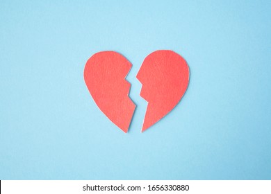 Red paper broken heart on bright background. Divorce, parting, therapy, love, psychologist, family ruined concept