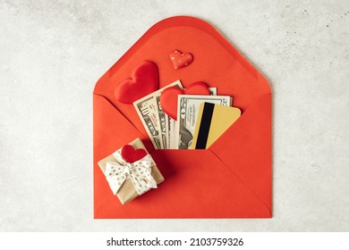 Red Paper Envelope With Money Dollars Bills And Credit Card. Flat Lay Of Gray Working Table Background With Valentine Gift, Letter, Heart Shape. Top View, Mock Up. Valentine's Day Budget